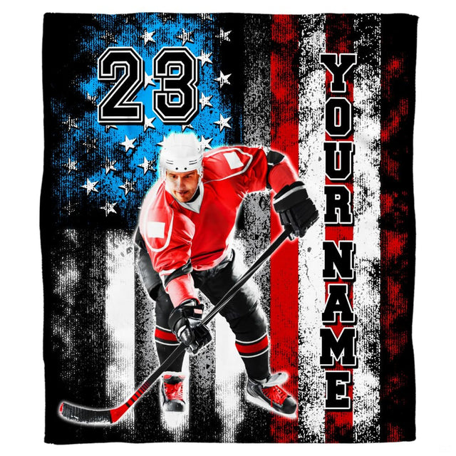 Folded patriotic ice hockey throw blanket displaying athlete in red jersey and weathered flag art
