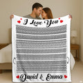 Couple holding up optical illusion throw blanket featuring hidden line art and red hearts in bedroom