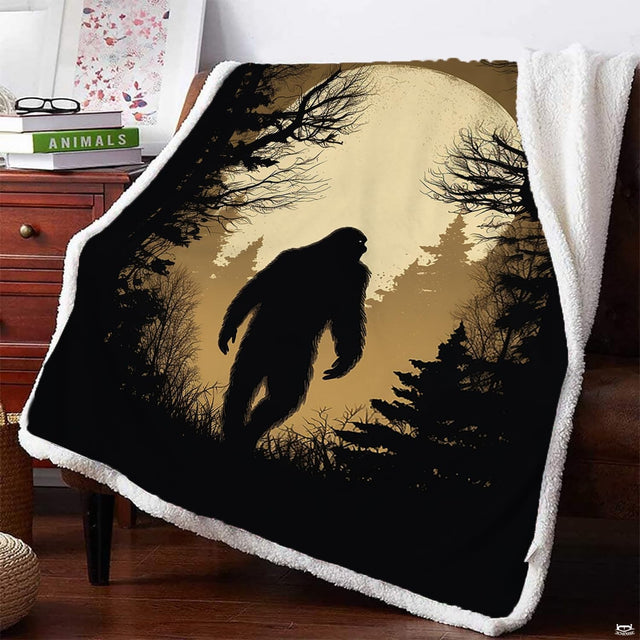 Bigfoot full moon blanket draped on armchair showing Sasquatch forest silhouette.