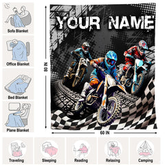 Folded motocross dirt bike racing throw blanket resting on wooden table displaying racing artwork