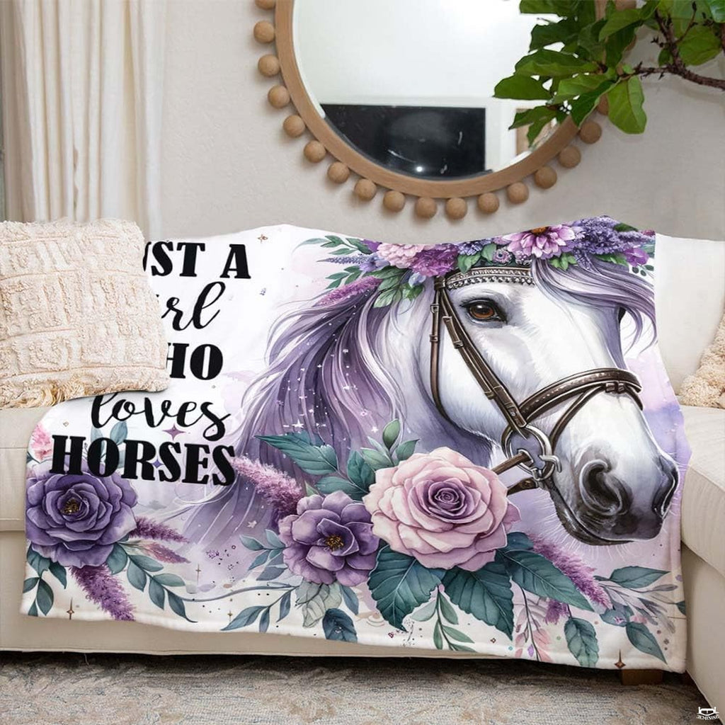 Close-up perspective of purple rose blossoms and white horse bridle on throw blanket