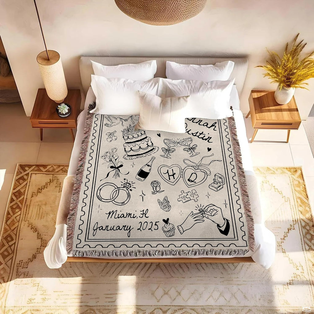 Detail of hand with engagement ring, heart lockets, and love doves line art on a romantic blanket