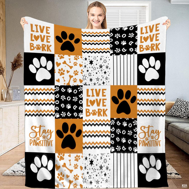 Puppy theme bedding featuring patchwork dog paw prints, bones, and chevron zigzag stripes in ochre, tan, and black.