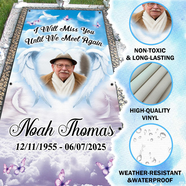 Close-up view of white angel wings and celestial heart-shaped sky window on memorial grave blanket.
