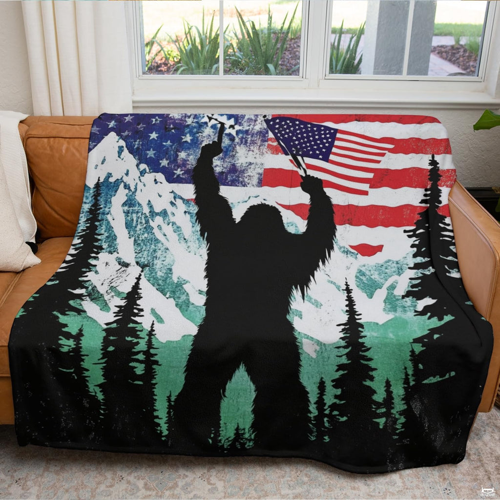 Patriotic Bigfoot blanket arranged across brown leather living room couch