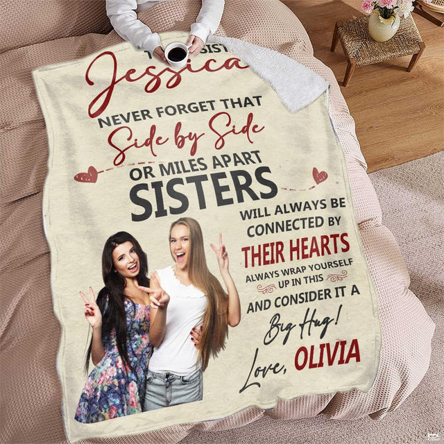 Person relaxing on furniture holding coffee mug with commemorative duo portrait blanket draped over lap.