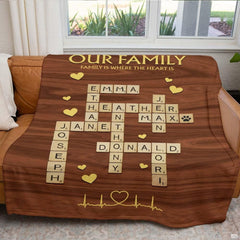 Lifestyle bedroom view showing the wooden letter tiles throw blanket styled across a bed.