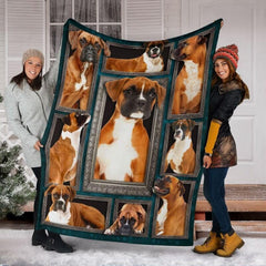 Two models displaying the Fawn Boxer Dog blanket outside a snowy winter home entrance.