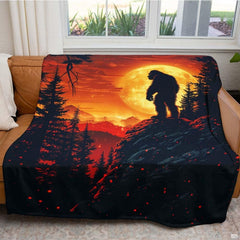 Folded Bigfoot cliff harvest moon throw blanket resting on wooden table displaying sunset artwork