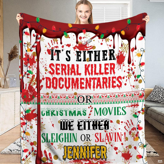 Young woman holding up white blanket displaying holiday string lights, bloody drips, and funny typography