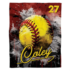 Flat view of yellow fastpitch softball blanket displaying crimson and black paint splatters