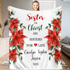 Red poinsettia floral holiday blanket displayed indoors.