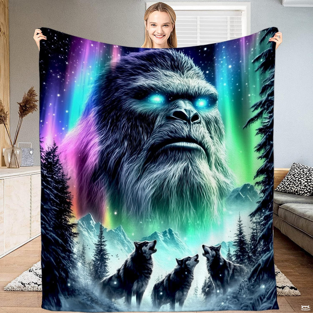 Woman displaying textile artwork of glowing Sasquatch emerging from northern lights above howling wolves.