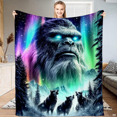 Woman displaying textile artwork of glowing Sasquatch emerging from northern lights above howling wolves.