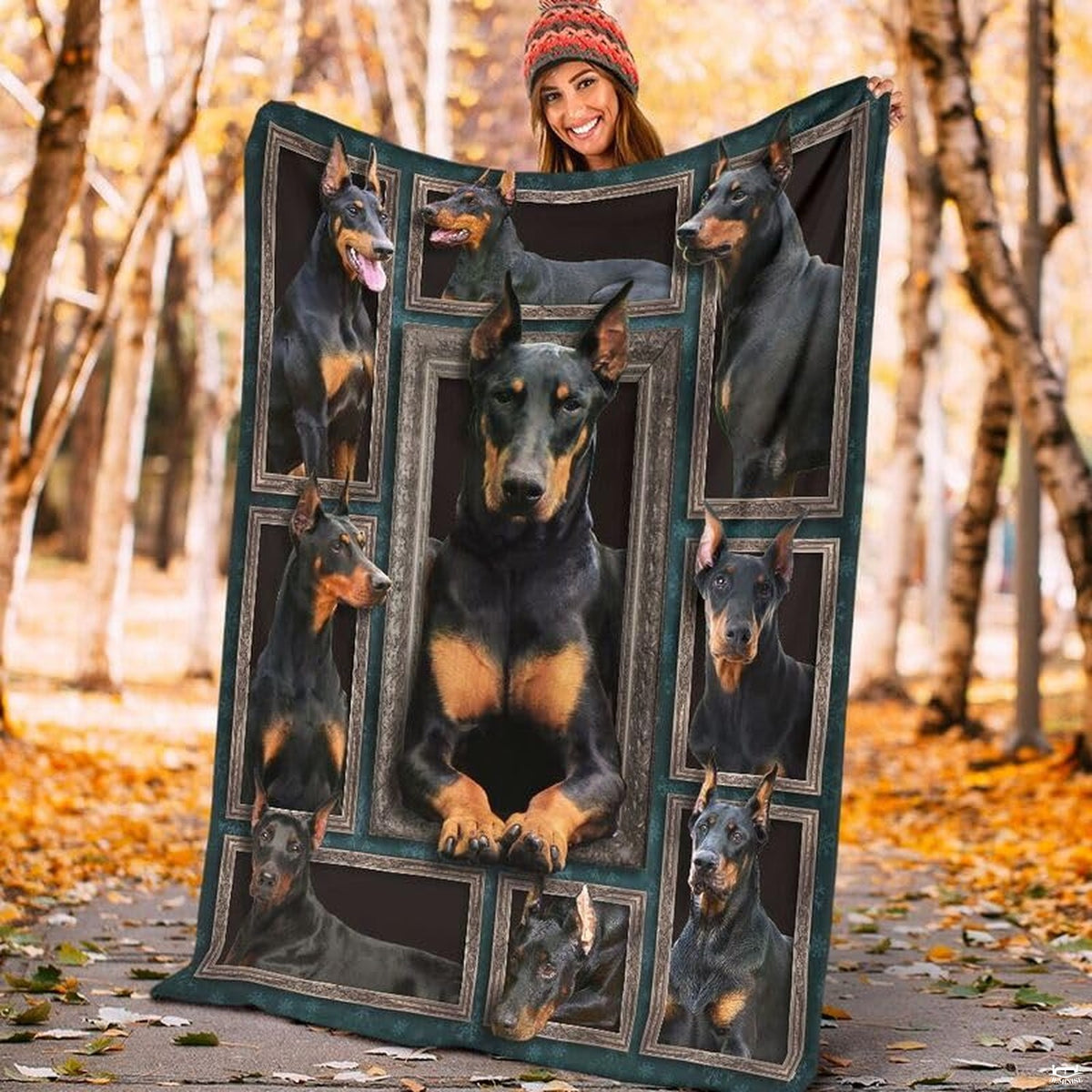 Model displaying the rectangular Doberman Pinscher portrait blanket outdoors in an autumn park.