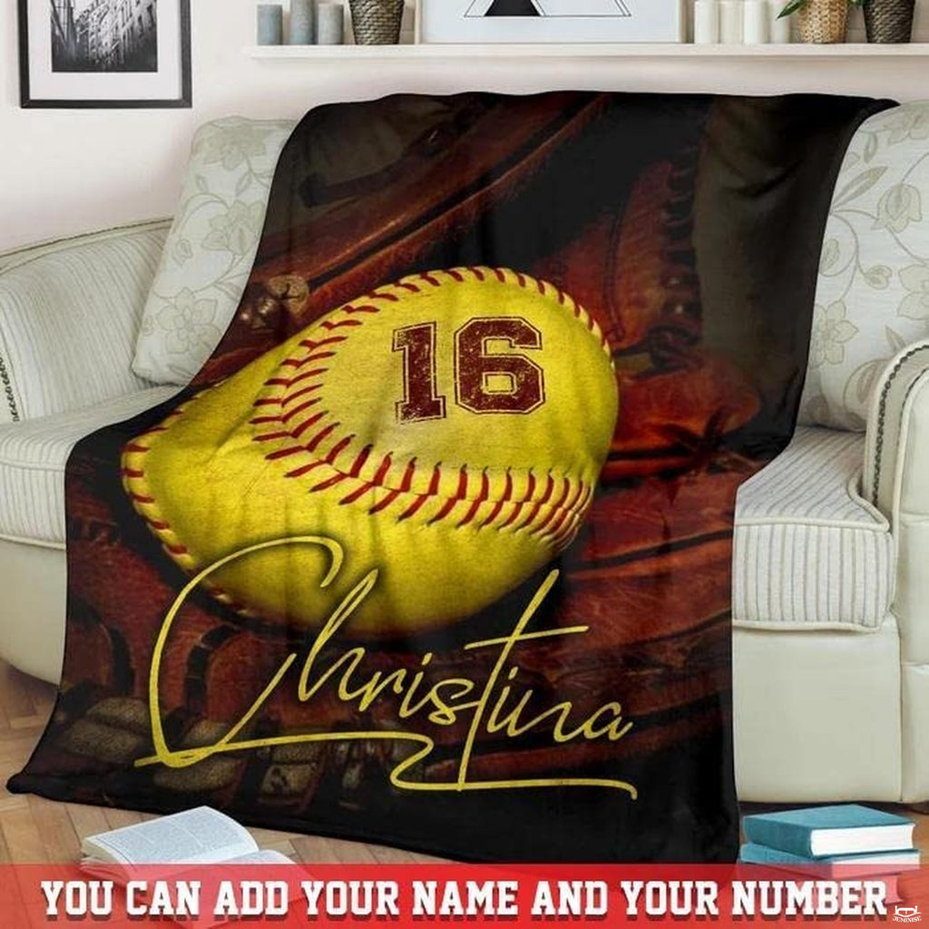 Softball and glove graphic throw blanket draped neatly over a cream living room sofa.