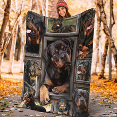 Model displaying the rectangular Rottweiler portrait blanket outdoors in an autumn park.