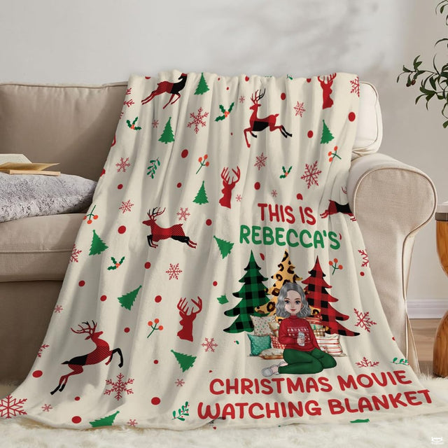 Living room staging of reindeer holiday throw blanket draped across a neutral sofa.