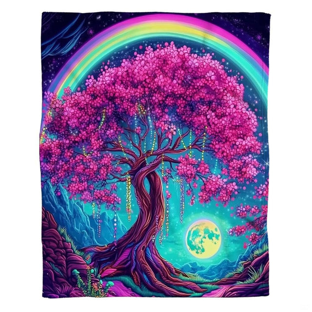Woman holding open cherry blossom tree throw blanket showing arching rainbow and mountain meadow