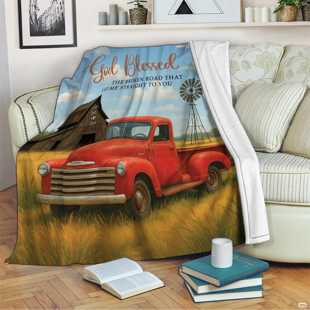 Vintage red pickup truck in golden wheat field with rustic barn and windmill, view 2.