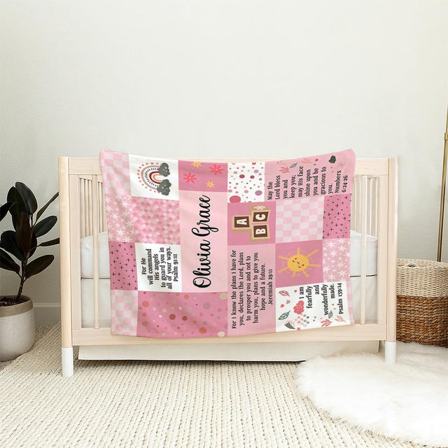 Detail of pink floral bed sheets design showing whimsical smiley sun and alphabet toy blocks