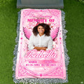 Top-down cemetery view showing pink angel wings tribute placed before a headstone on gravel.