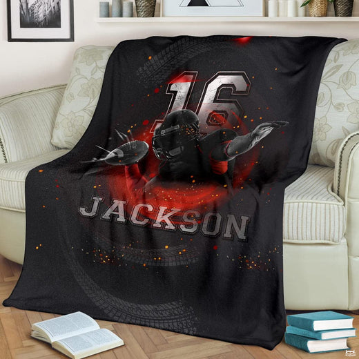 Gridiron athletic midair catch ember blanket draped over sofa