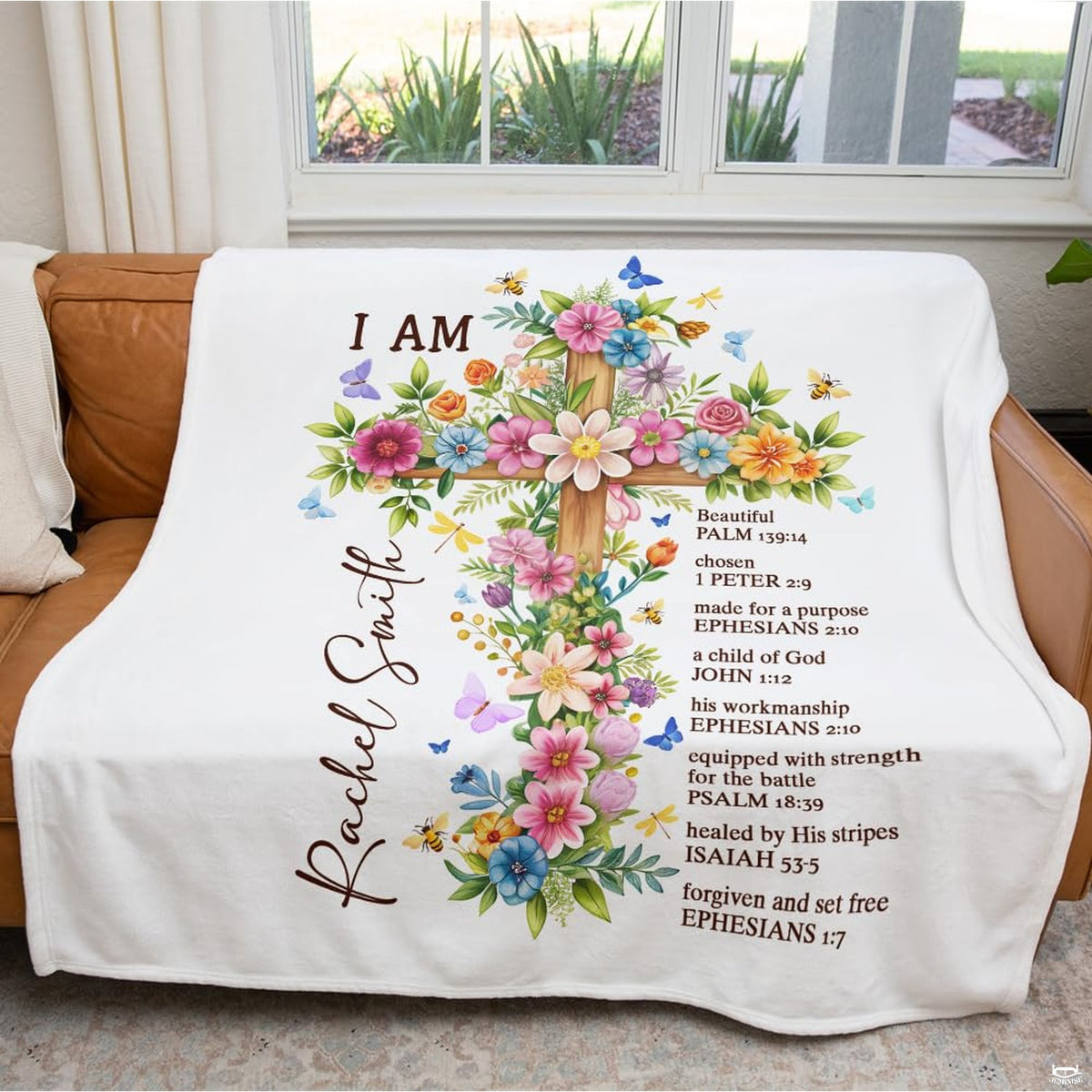 Floral cross faith throw blanket styled across a couch in a bright living room.