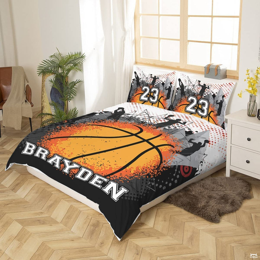 Top-down view of orange splatter basketball sports bedding set arranged neatly on a modern youth bed