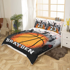 Top-down view of orange splatter basketball sports bedding set arranged neatly on a modern youth bed