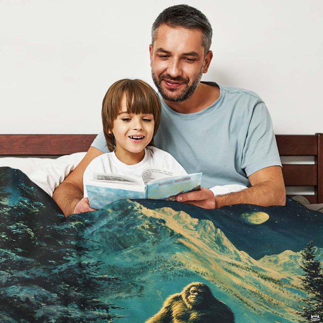 Snowy alpine Bigfoot mountain throw blanket view 2 styled on living room couch in modern home