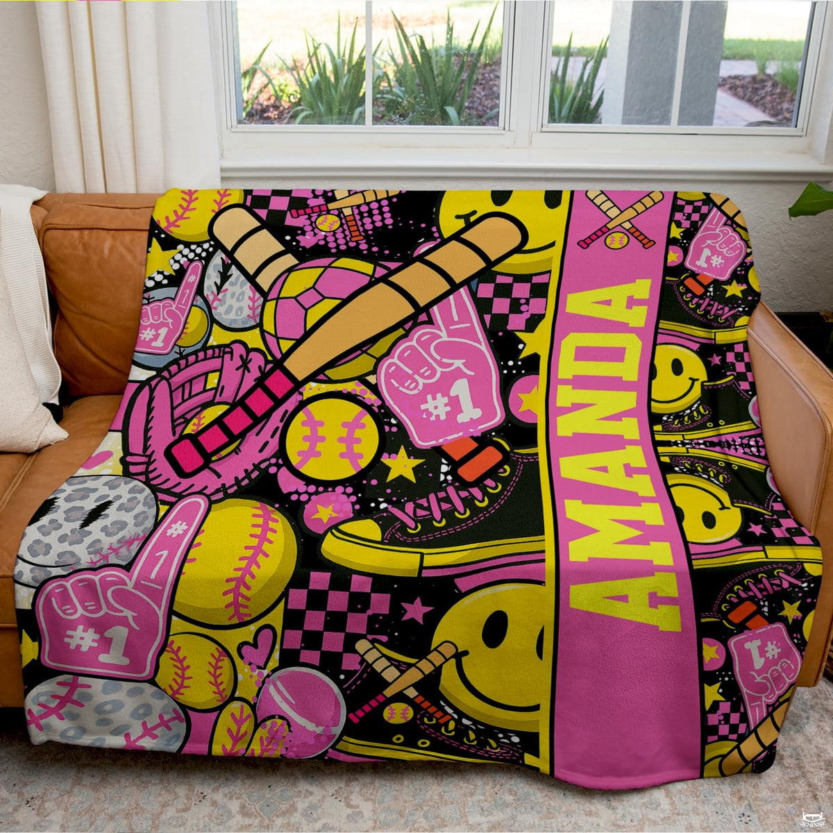 Folded view of pink softball throw blanket showcasing crossed bats and checkerboard prints.