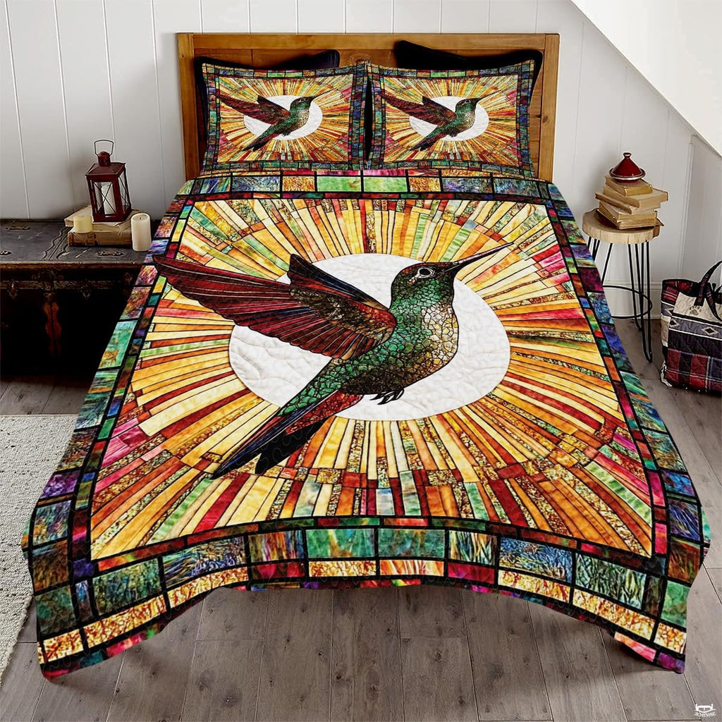Green and red hummingbird before a white circle and amber mosaic sunburst
