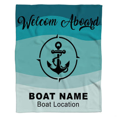 Flat layout of nautical blanket featuring central anchor compass design over aqua wave bands