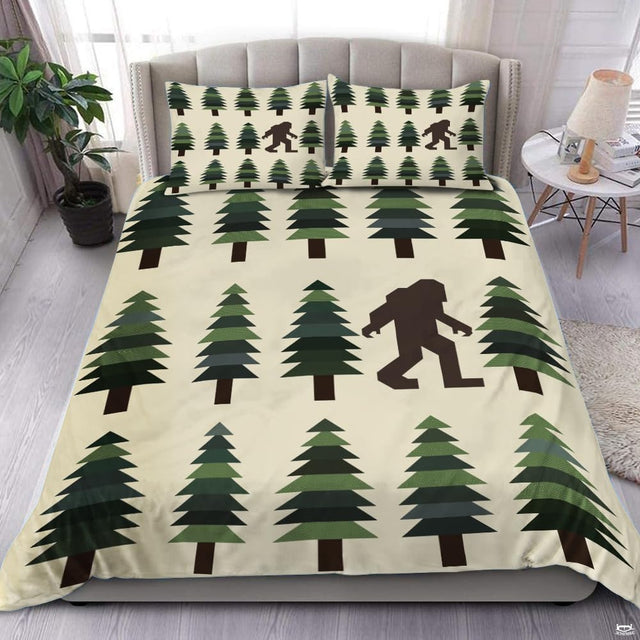 Sasquatch pine bedding featuring a walking silhouette among patterned green trees on cream backdrop