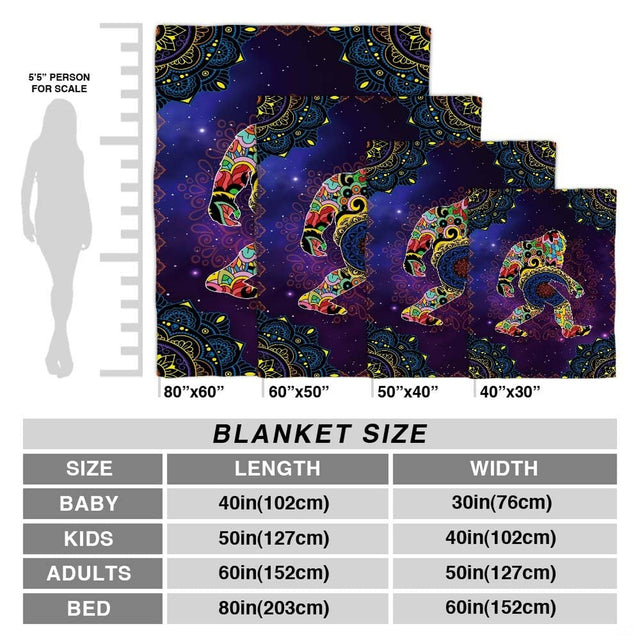 Model holding open the colorful mandala Bigfoot blanket in a modern living room setting.