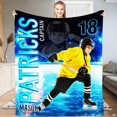 Folded youth ice hockey throw blanket revealing golden jersey graphic and electric blue ice