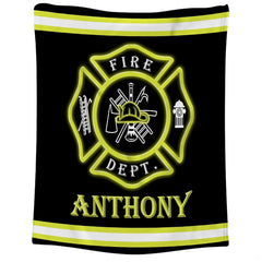 Close-up of the red Maltese cross badge displaying firefighter helmet, ladder, axe, and hydrant icons on a blanket