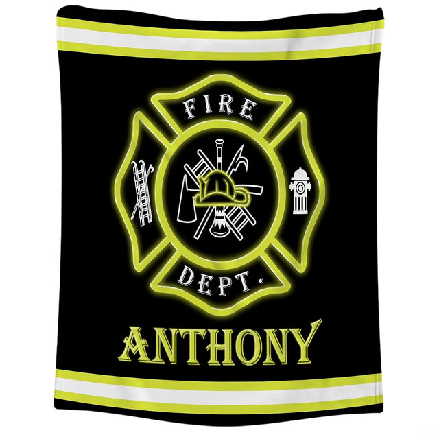 Close-up of the red Maltese cross badge displaying firefighter helmet, ladder, axe, and hydrant icons on a blanket