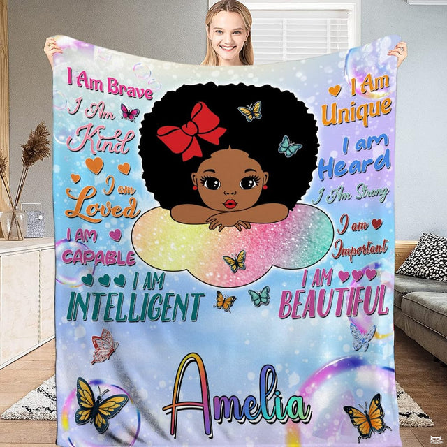 Full view of rainbow cloud affirmations blanket held up indoors.