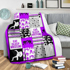 Flat layout of purple and black wrestling blanket displaying athlete silhouettes and chevron patterns.