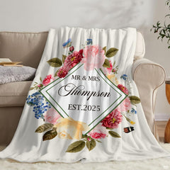 Romantic floral wedding throw blanket draped across a modern bedroom bed setting in a master suite