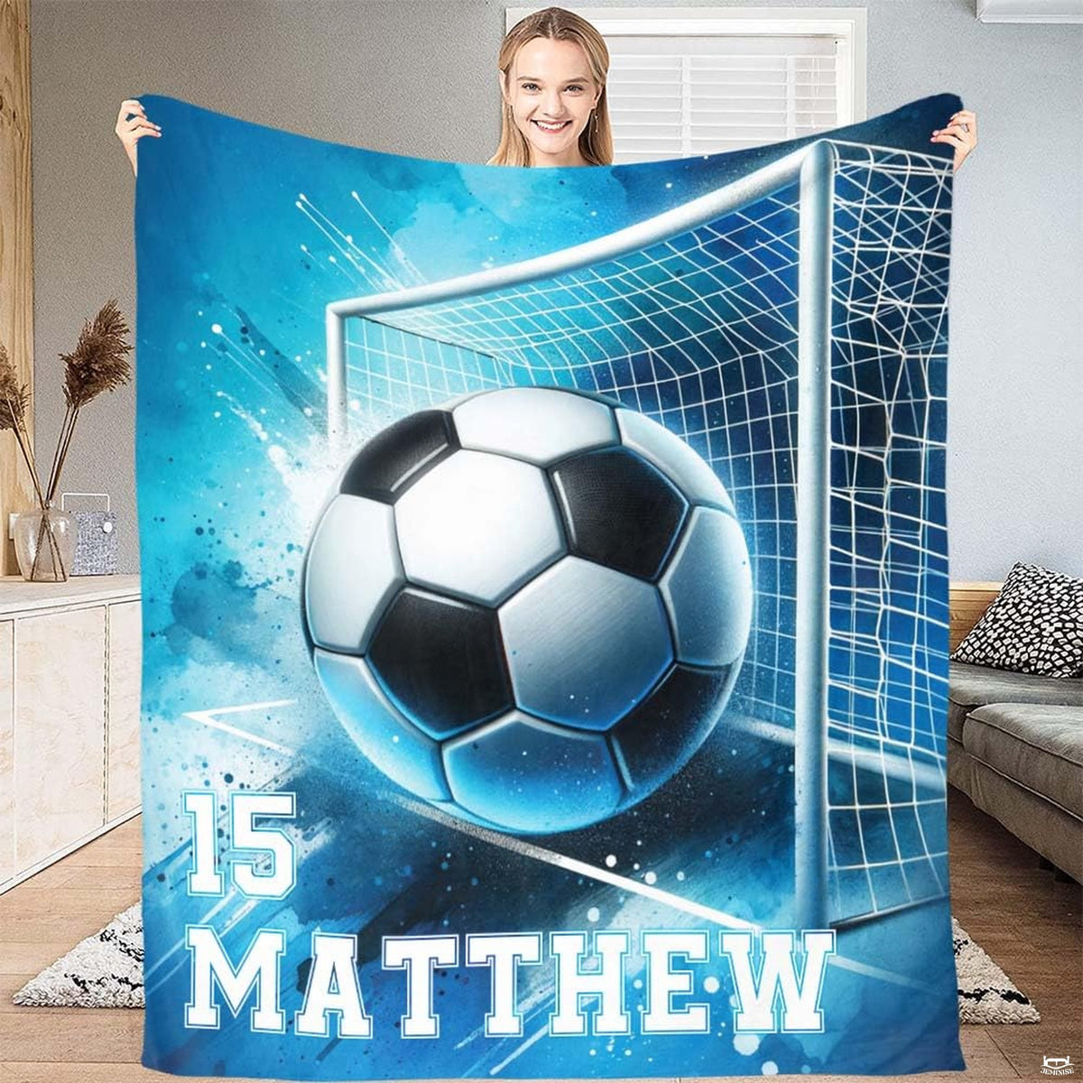 Person presenting the blue watercolor soccer goal artwork with vibrant paint splatters.