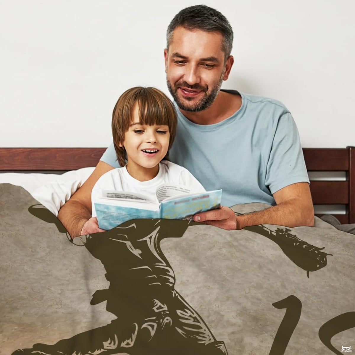 Father and child reading a storybook comfortably covered under the sports throw blanket.