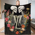 Gothic floral skeleton lovers throw blanket featuring embracing skeletons and a colorful wildflower wreath