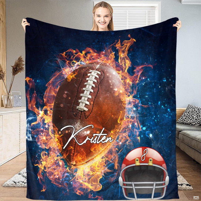Woman holding up fire football throw blanket displaying glowing flames and cosmic sports graphics