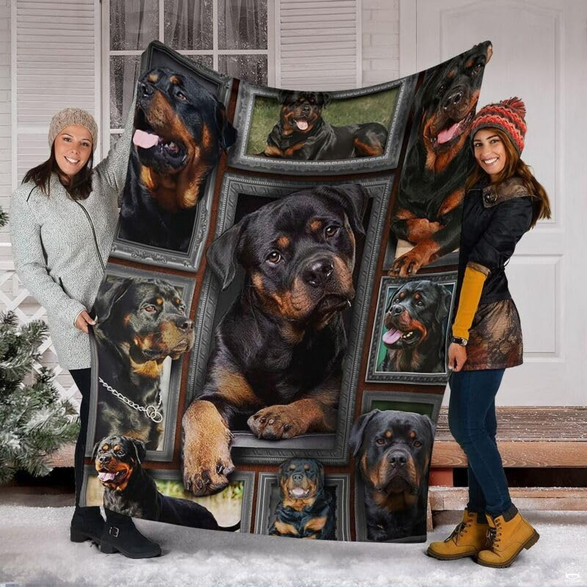 Two models displaying the Rottweiler blanket outside a snowy winter home entrance.