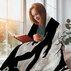 Full moon Bigfoot throw blanket styled around a person reading by a sunny window.