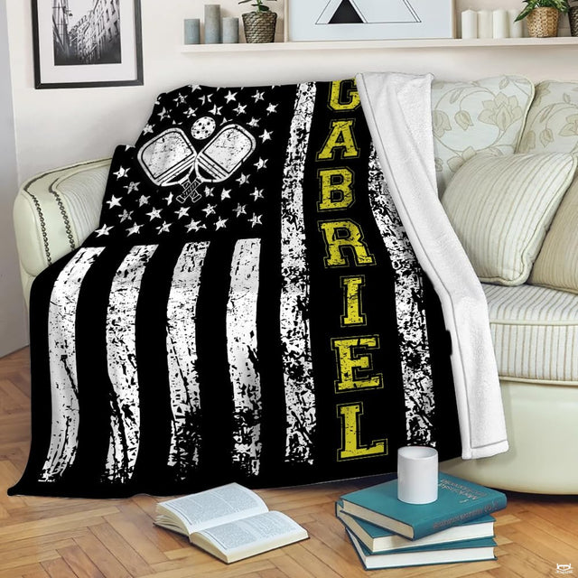 Distressed American flag graphic with crossed pickleball paddles and yellow lettering, view 1.