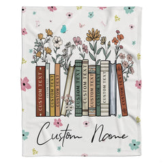Model displaying the floral book throw blanket in a bright modern home interior.